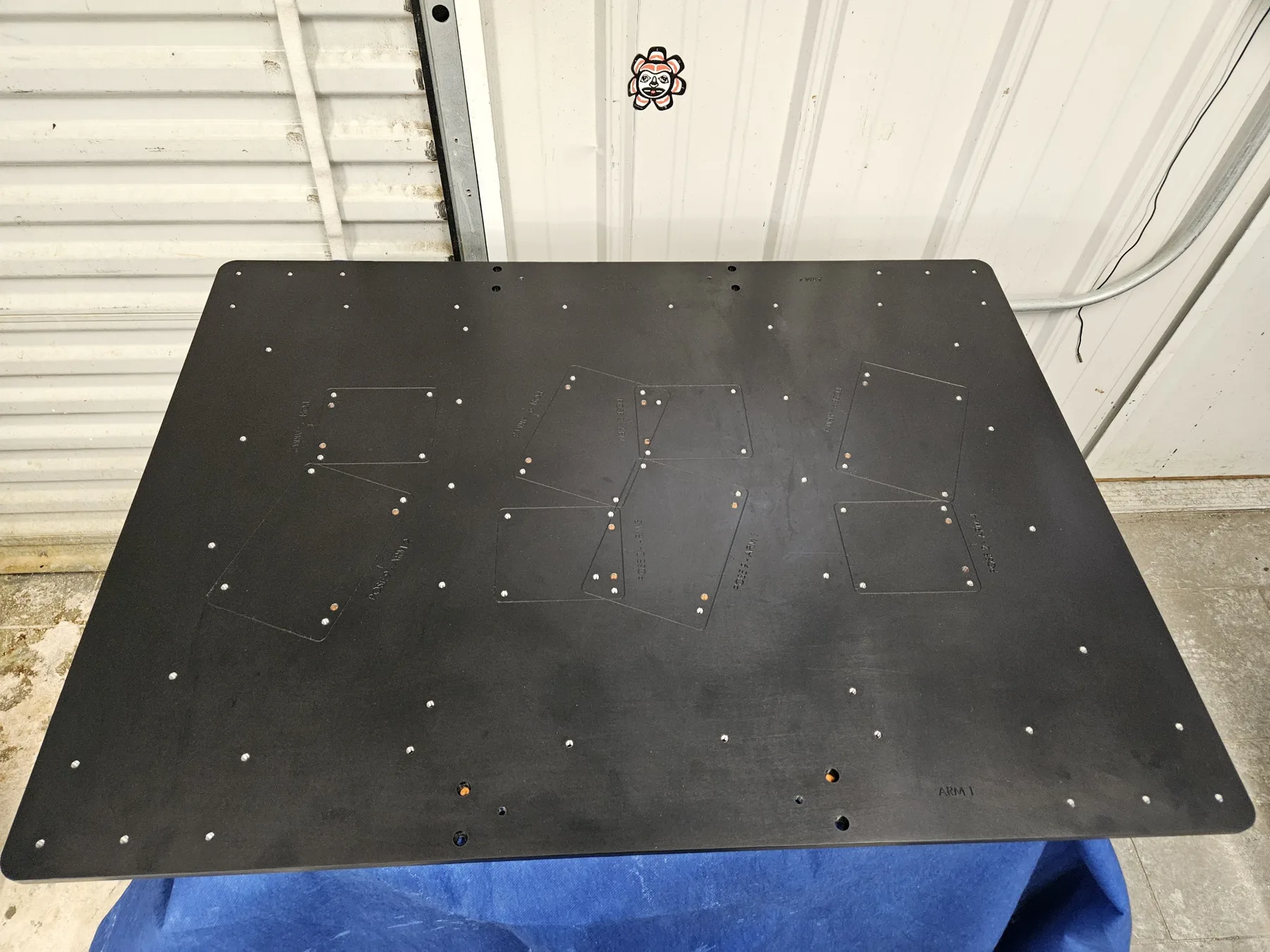 Large black anodized aluminum plate with a machined hole pattern finished at AnoPRO