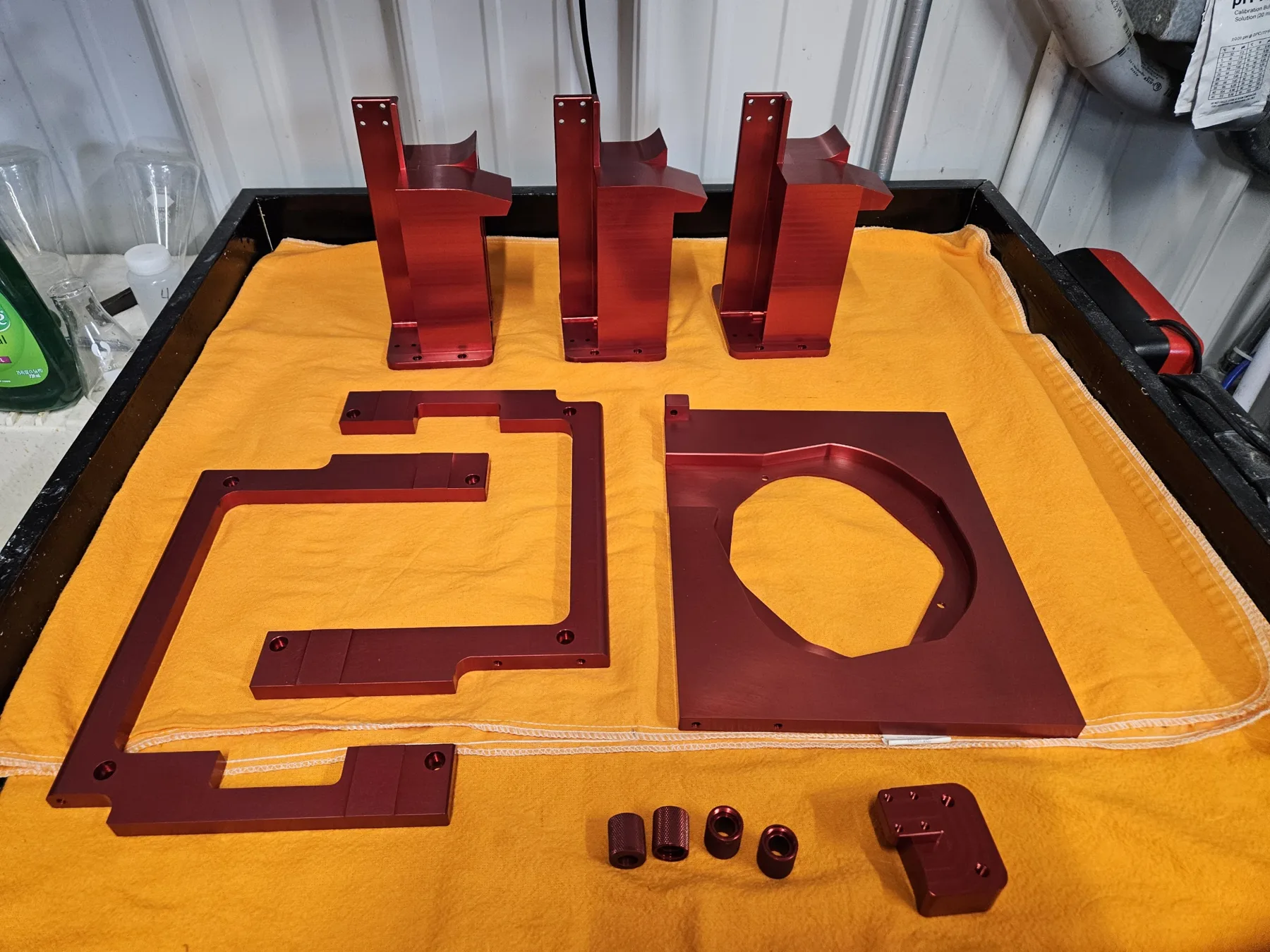 Red anodized aluminum brackets, plates, and fittings finished at AnoPRO
